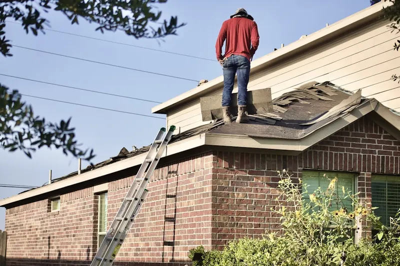Professional roofer working on a residential roof in Great Neck
